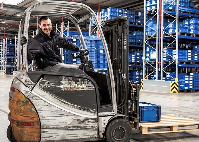 Staplerleitsystem: Transporte effizient steuern Ein Gabelstapler bewegt wegeoptimiert Paletten in einem großen Lagerbereich, gesteuert durch das L-mobile Staplerleitsystem. Das System ermöglicht Echtzeit-Lokalisierung mittels GPS, vermeidet Leerfahrten und reduziert Suchzeiten für maximale Transparenz und Effizienz in der Intralogistik