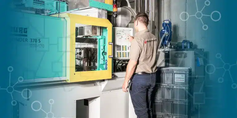 Un agent de production ajuste les paramètres d’une machine industrielle dans un atelier de fabrication.