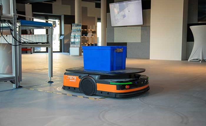 Ein KLT wird von einem fahrerlosen Transportsystem (FTS) ins Lager transportiert – gesteuert über Microsoft Dynamics 365 Business Central / NAV.