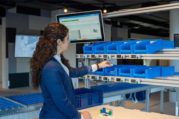 Ein Werker entnimmt Bauteile aus dem KLT und schließt den Fertigungsauftrag digital ab Ein Werker entnimmt Bauteile aus dem KLT und schließt den Fertigungsauftrag digital ab – unterstützt durch Microsoft Dynamics 365 Business Central / NAV.