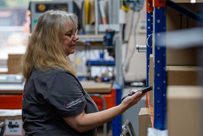 Eine Mitarbeiterin im Lager arbeitet mit der mobilen Scannerlösung für MS Dynamics 365 Business Central und MS Dynamics NAV und spart sich so die Arbeit mit Papier.
