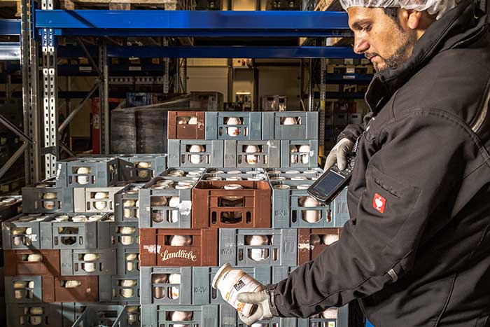 Ein Mitarbeiter im Lager scannt ein chargenpflichtiges Produkt mit der mobilen Datenerfassung für NAV (Navision) und Microsoft Dynamics 365 Business Central