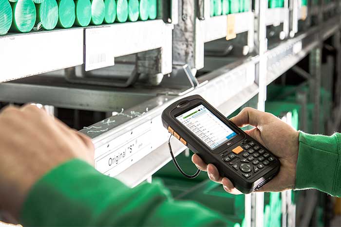 Ein Mitarbeiter im Lager erfasst Daten mit der mobilen Datenerfassung NAV und Microsoft Dynamics 365 Business Central.