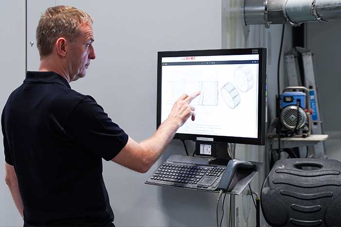 Mann bedient Maschine in der Produktion mit Hilfe von BDE Software zur Erfassung von Betriebsdaten
