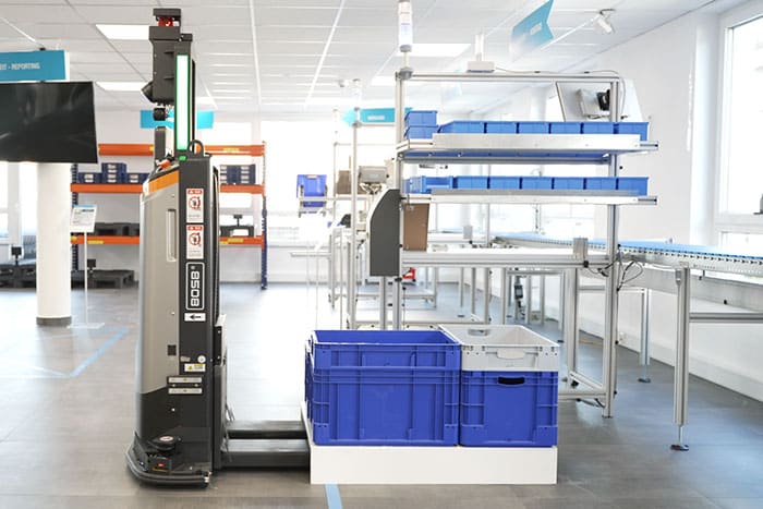 Der fahrerlose Gabelstapler lädt transportierte Waren sicher in der Entladezone ab,