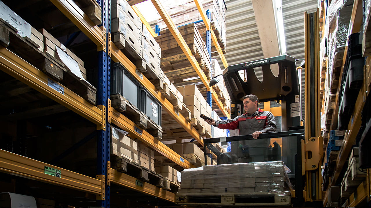 Lagermitarbeiter arbeitet mit einem Scanner und der mobilen Lagerlösung L-mobile warehouse im Lager Lagermitarbeiter arbeitet mit einem Scanner und der mobilen Lagerlösung L-mobile warehouse im Lager