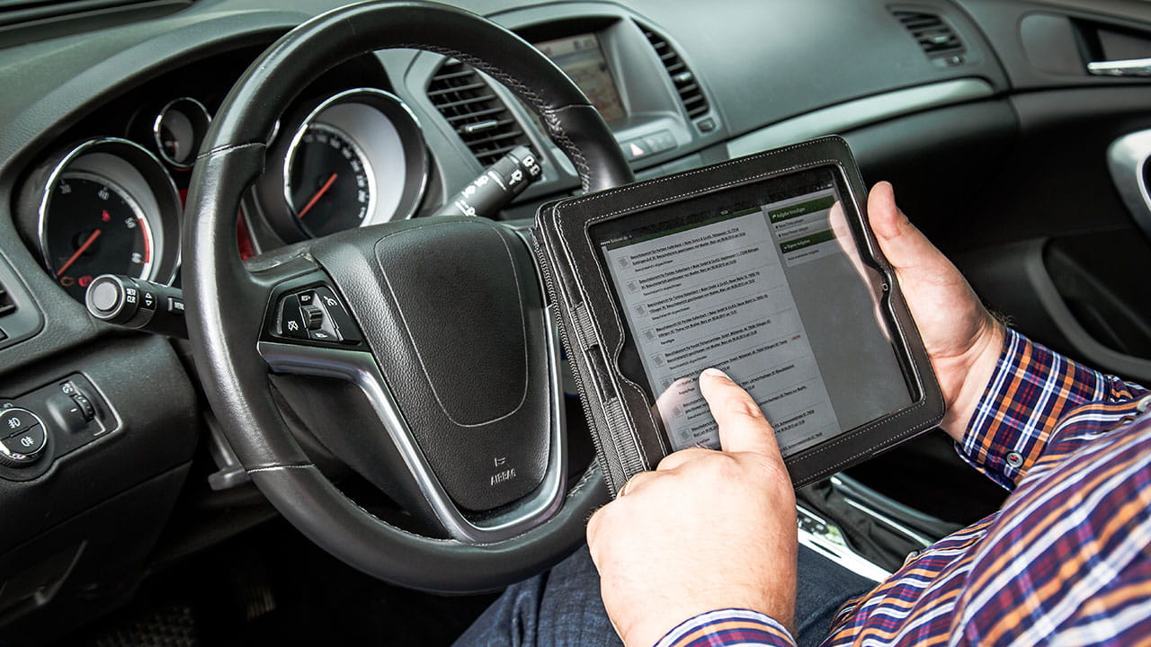 vertriebler-mit-tablet-und-l-mobile-sales Außendienstvertriebler arbeitet mobil mit einem Tablet und L-mobile sales