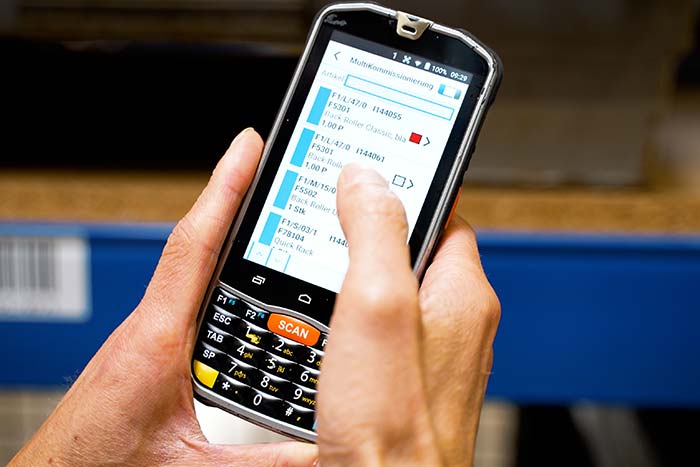 Mobiler Scanner mit einer Lagerverwaltungssoftware im Einsatz im Lager Mobiler Scanner mit einer Lagerverwaltungssoftware im Einsatz im Lager